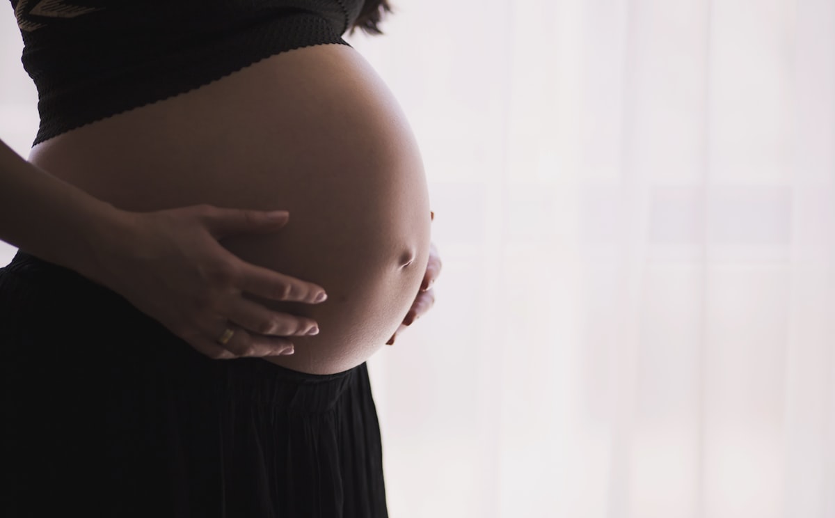 pregnant woman cradling her belly